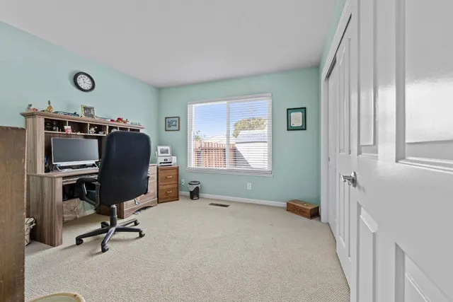 a view of a workspace with furniture and a window