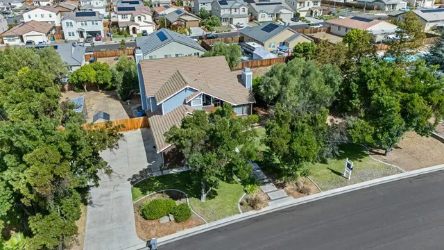 an aerial view of residential house with outdoor space and trees all around