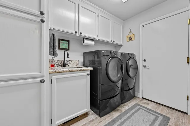 a utility room with cabinets washer and dryer