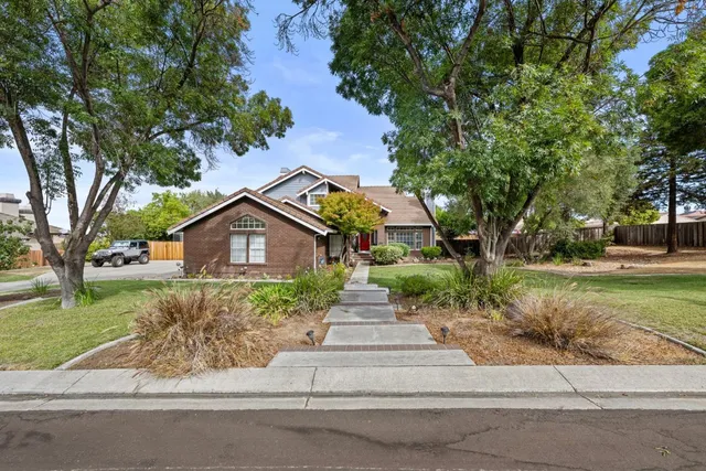 a front view of a house with a yard and potted plants