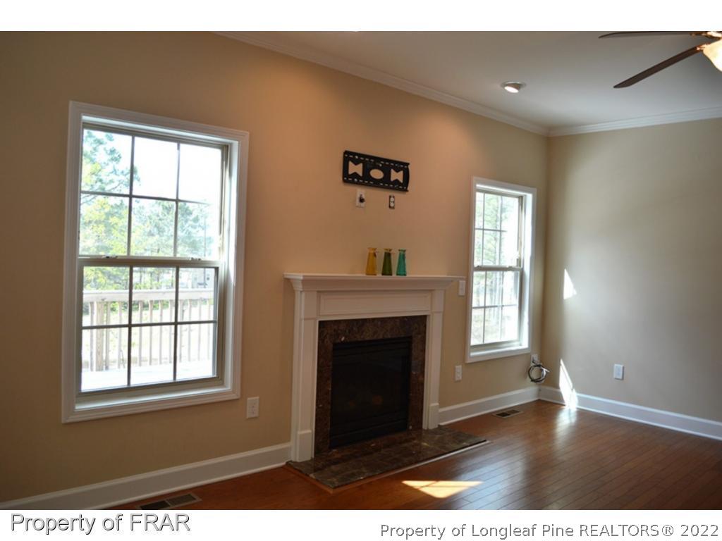 1105 Micahs Way North Spring Lake, NC 28390 - Photo 15 of 32 a view of an empty room with a window and wooden floor