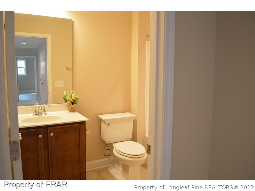 1105 Micahs Way North Spring Lake, NC 28390 - Photo 23 of 32 a bathroom with a toilet a sink and mirror