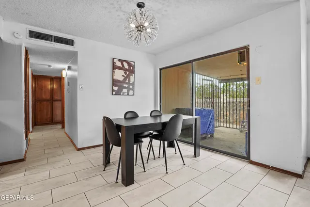a view of a dining room with furniture and a chandelier
