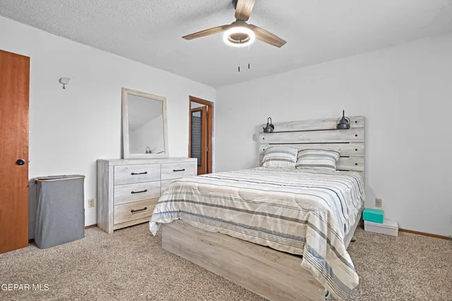 a bedroom with a large bed and a chandelier