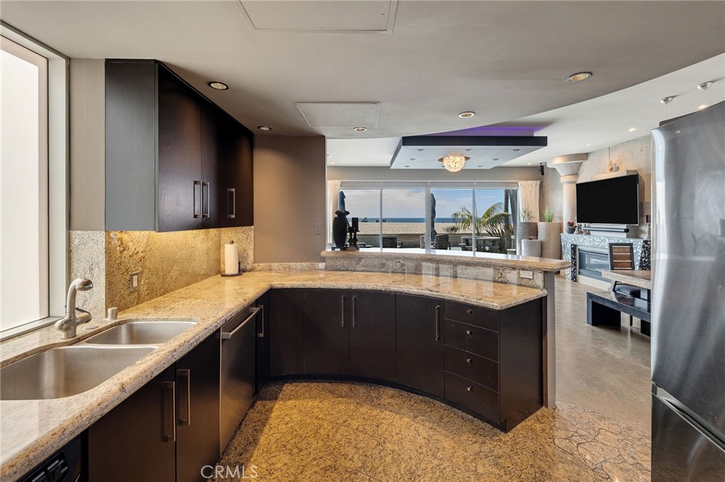 2024 The Strand Hermosa Beach, CA 90254 - Photo 18 of 65 a kitchen with a sink and a stove top oven with wooden cabinets