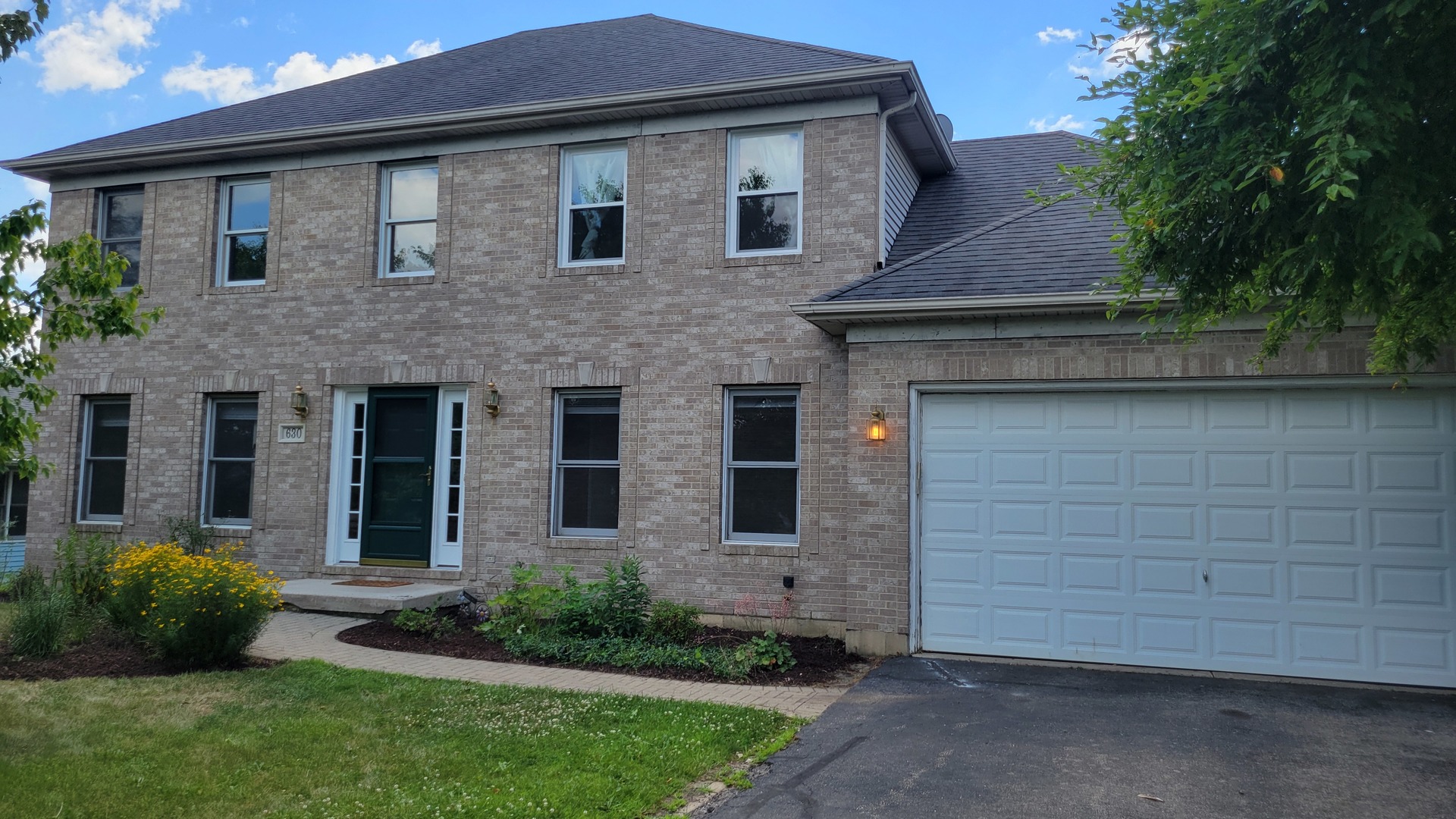 a front view of a house with a garden