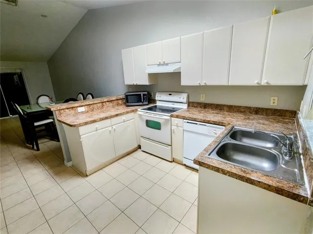 a kitchen that has a sink and a stove top oven
