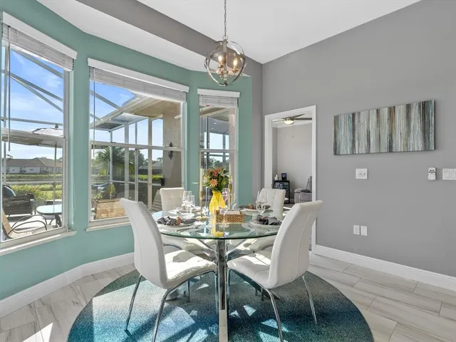 a dining room with furniture a chandelier and wooden floor