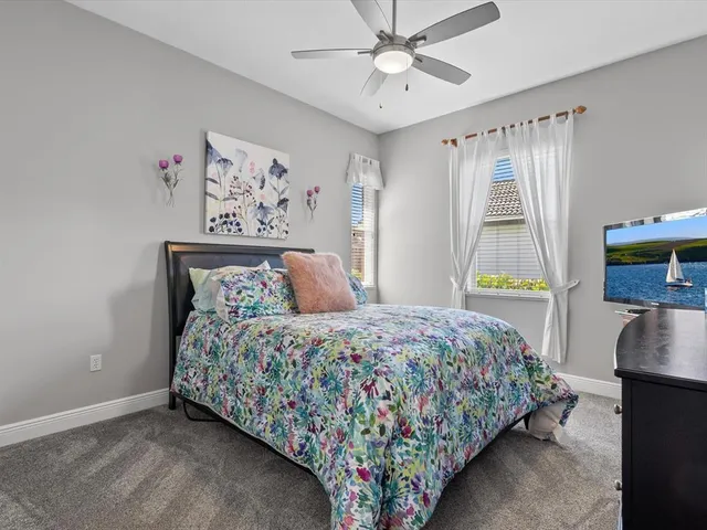 a bedroom with a bed a table and a chandelier