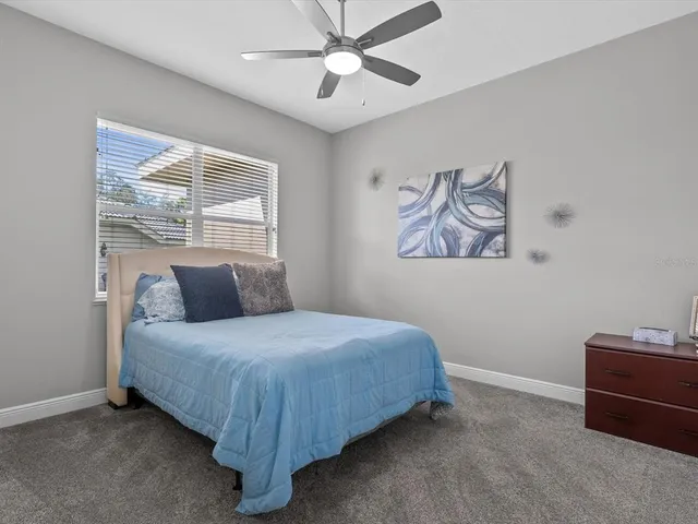 a bedroom with a bed dresser and a flat tv screen