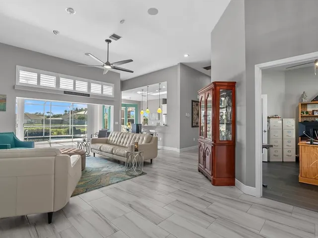 a living room with furniture large window and wooden floor