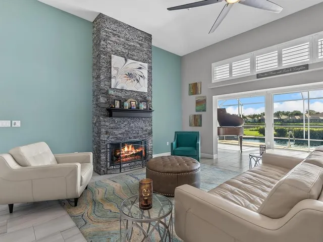 a living room with furniture a fireplace and a large window