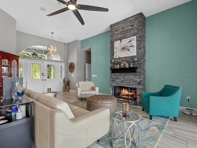 a living room with furniture a fireplace and a chandelier