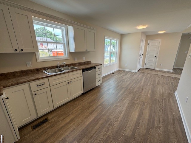 80 Modena Place Decherd, TN 37324 - Photo 4 of 14 a kitchen with granite countertop wooden floors white cabinets and sink