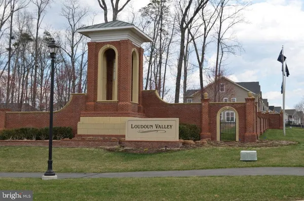 a view of a house with a yard and large trees