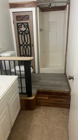 a view of a refrigerator in kitchen and an empty room