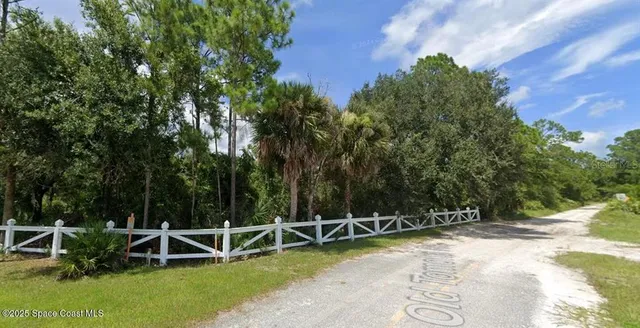 a view of a wooden bench sitting in the middle of a yard