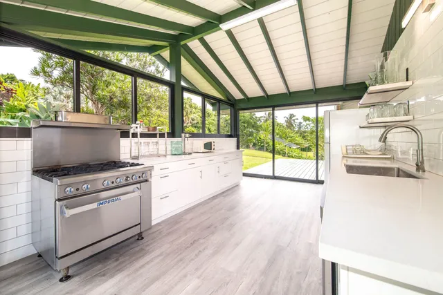 a kitchen with a stove a sink and a wooden floor