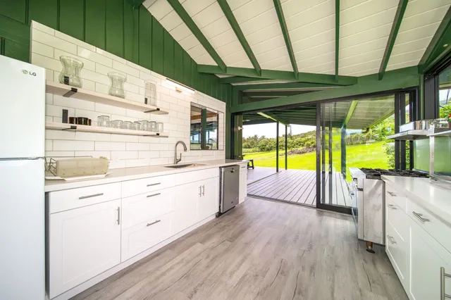 a kitchen with stainless steel appliances wooden floors and white walls
