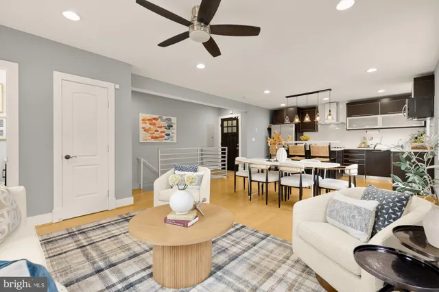 a living room with furniture and a view of kitchen