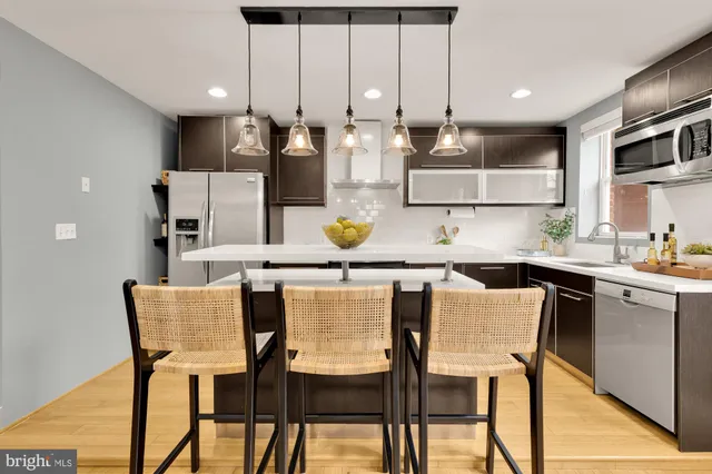 a kitchen with stainless steel appliances kitchen island granite countertop a table and chairs