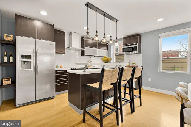 a kitchen with stainless steel appliances kitchen island granite countertop a refrigerator and microwave