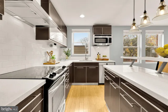 a kitchen with stainless steel appliances a sink stove and microwave