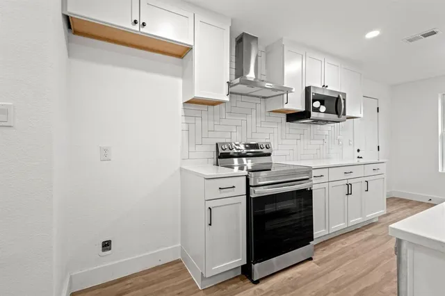 a kitchen with cabinets and stainless steel appliances