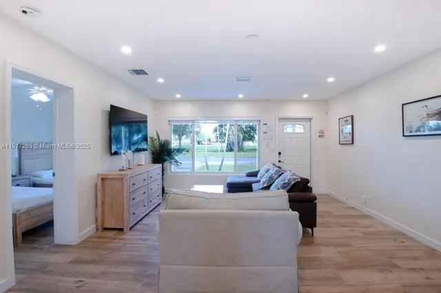 a living room with furniture wooden floor and a flat screen tv
