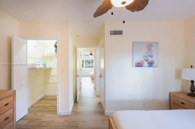 a view of a hallway with wooden floor and cabinet