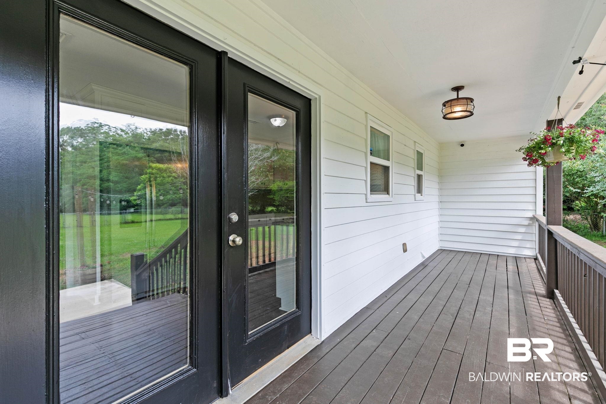 22810 High Ridge Road Fairhope, AL 36532 - Photo 60 of 78 Covered porch featuring dark-stained wood flooring, white horizontal siding, and a dark-stained wood railing
