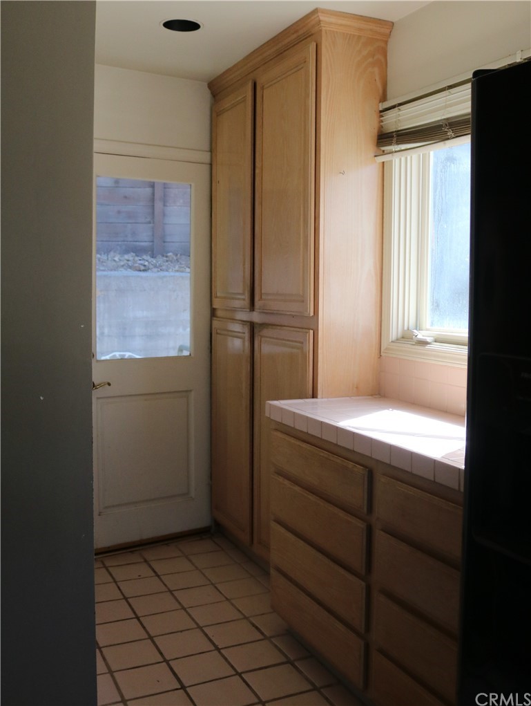 183 Lower Terrace Road Avalon, CA 90704 - Photo 21 of 33 a room that has a window in it and wooden cabinets