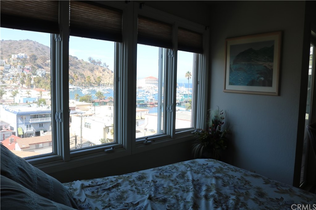 183 Lower Terrace Road Avalon, CA 90704 - Photo 29 of 33 a bedroom with a bed and wooden floor