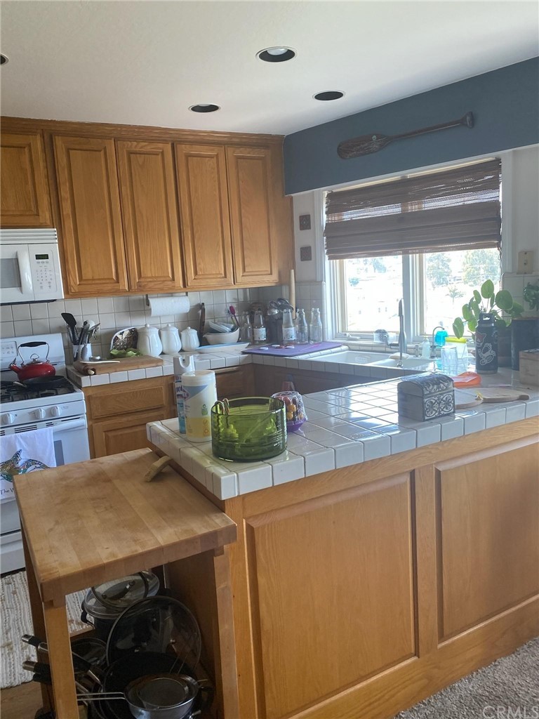 183 Lower Terrace Road Avalon, CA 90704 - Photo 4 of 33 a kitchen with a sink a stove and a refrigerator