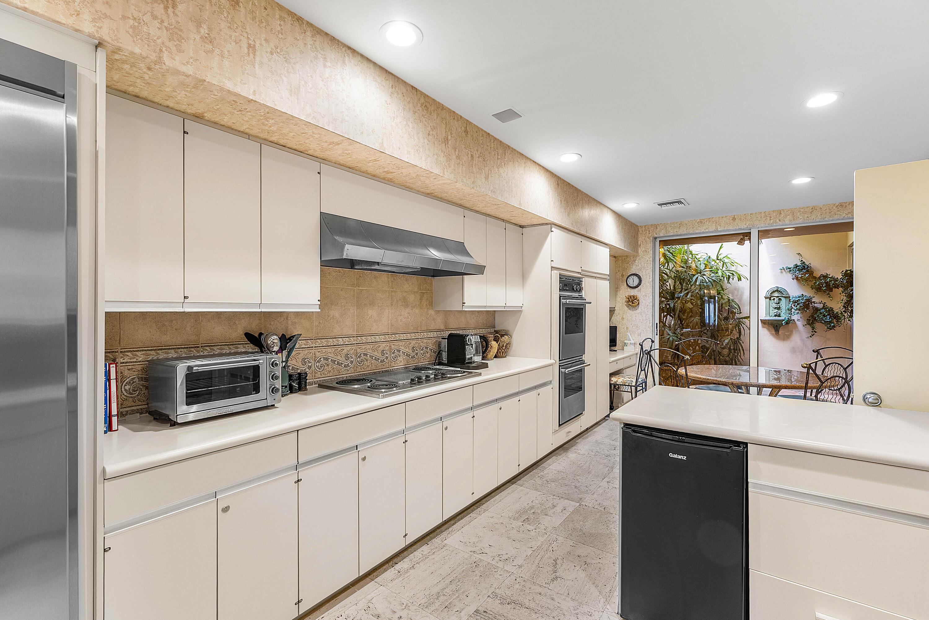 13 Sloans Curve Drive, Unit 13 Palm Beach, FL 33480 - Photo 16 of 47 a kitchen with stainless steel appliances a sink stove and cabinets
