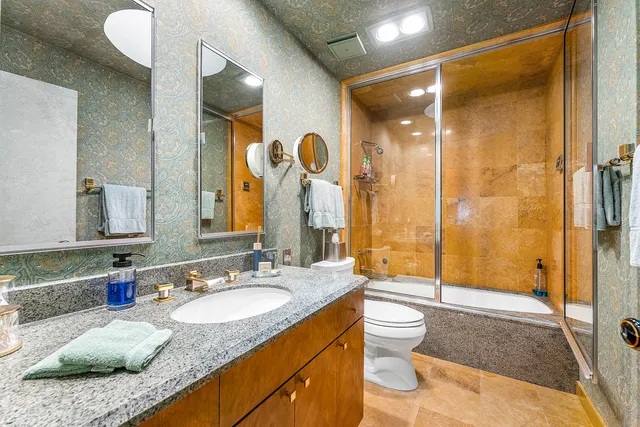 a bathroom with a granite countertop sink toilet and shower