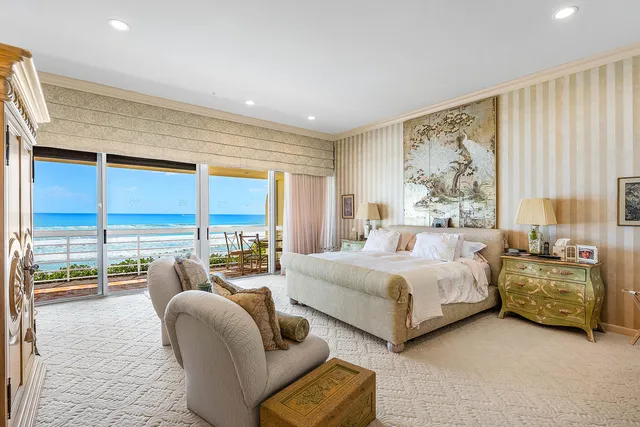 a spacious bedroom with a bed and glass walk in closet