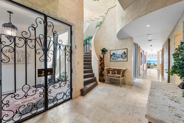a view of a hallway with stairs and furniture