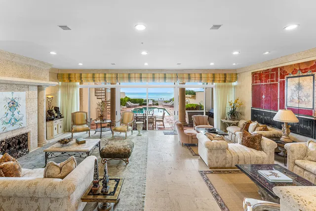 a living room with furniture kitchen view and large windows