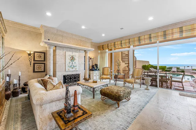 a living room with furniture large windows and wooden floor