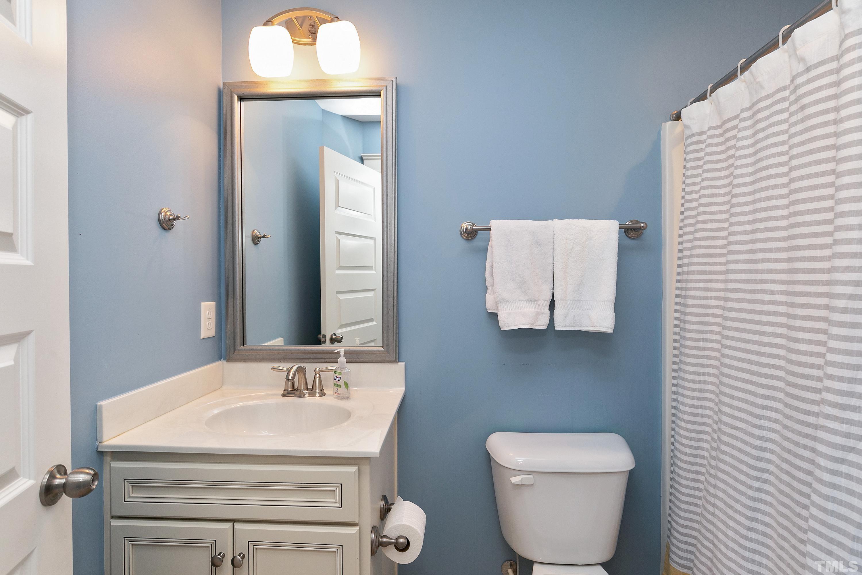 7906 Allscott Way Raleigh, NC 27612 - Photo 24 of 30 a bathroom with a toilet sink and mirror