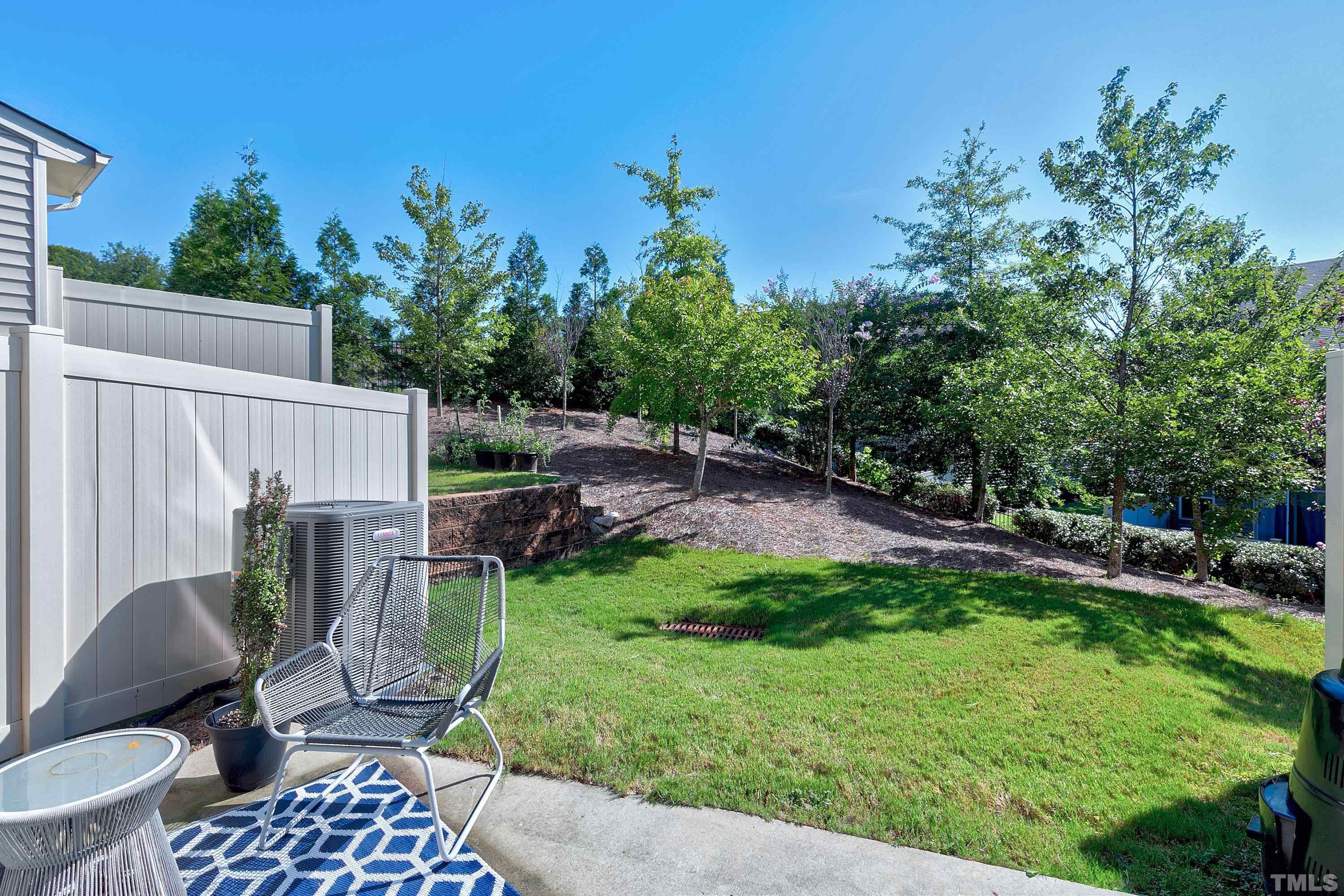 7906 Allscott Way Raleigh, NC 27612 - Photo 29 of 30 a backyard of a house with table and chairs plants and large tree
