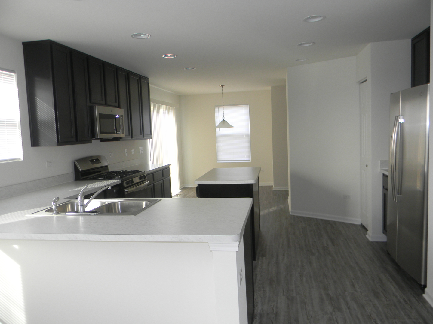 6616 Eich Drive Joliet, IL 60431 - Photo 7 of 20 a kitchen with a sink a microwave a refrigerator and cabinets