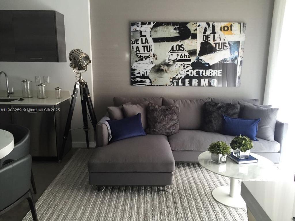 151 Southeast 1st Street, Unit 903 Miami, FL 33131 - Photo 4 of 8 a living room with furniture and a flat screen tv