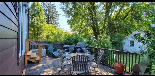 a view of a chair and table in backyard of the house