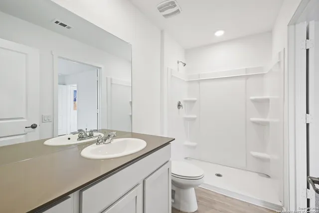 a bathroom with a sink a toilet and a mirror