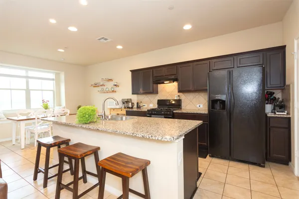 a kitchen with granite countertop a refrigerator and a sink