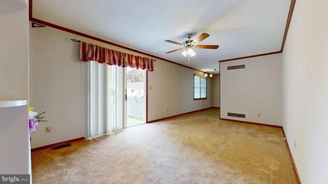 an empty room with windows and ceiling fan