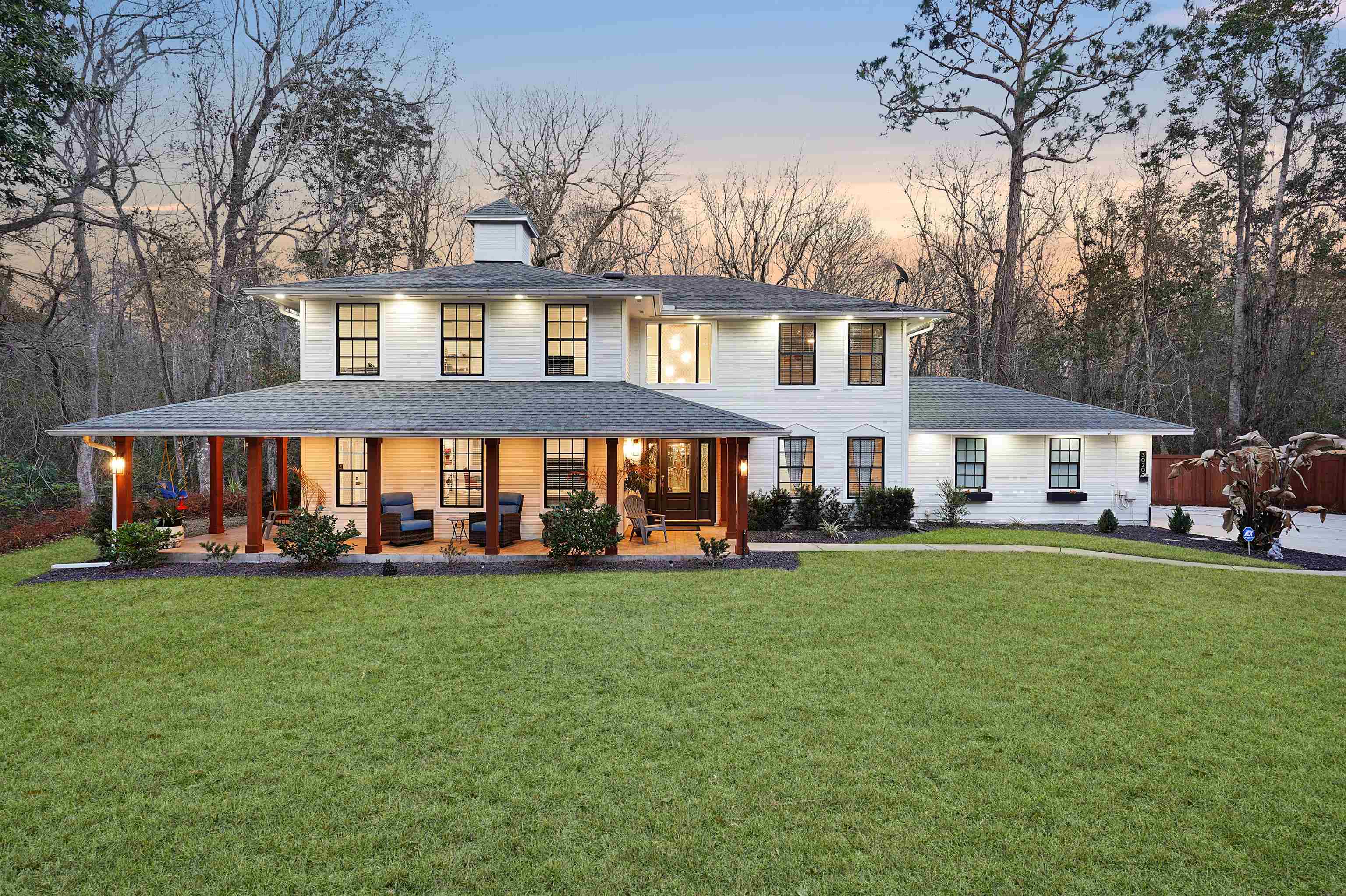 Back of property with covered porch, a yard, and a chimney