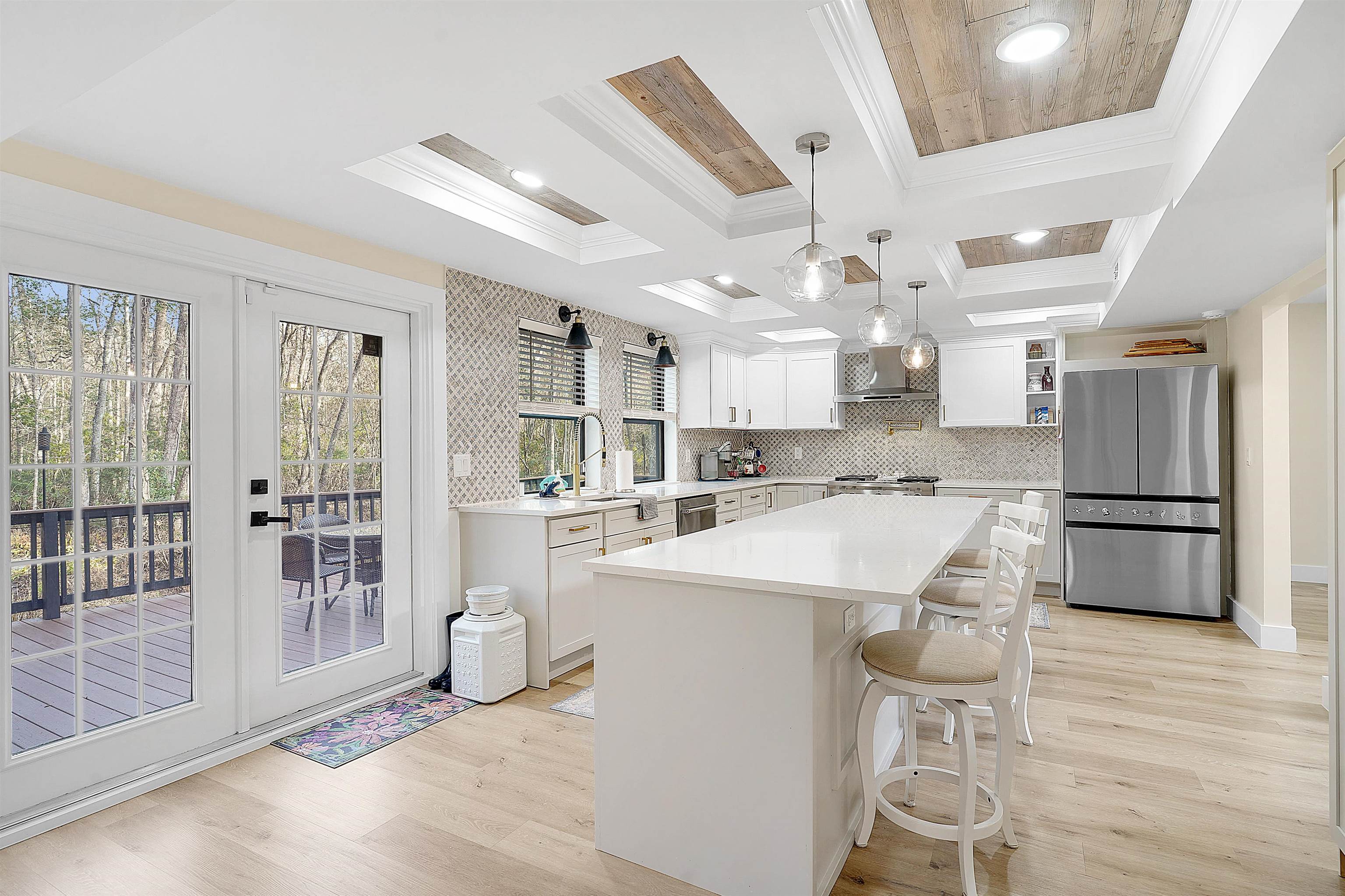 3020 Mac Road St. Augustine, FL 32086 - Photo 16 of 49 Kitchen with a kitchen breakfast bar, stainless steel appliances, a kitchen island, light wood-style flooring, and decorative light fixtures